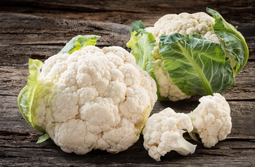 Coliflor Una coliflor fresca de color blanco intenso con sus hojas verdes, lista para ser procesada.