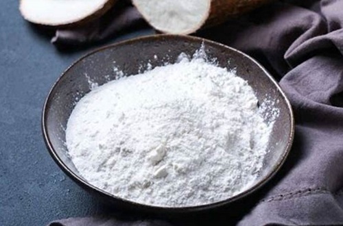 Fécula de mandioca Polvo blanco fino y sedoso de mandioca en un bol de madera, ingrediente clave de la elasticidad.