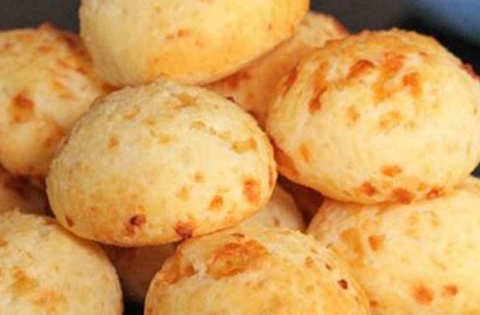 Chipa con fécula de mandioca: Receta casera, crujiente y sin gluten Varias bolitas de chipa doradas y humeantes en un canasto de mimbre, mostrando una superficie agrietada y crujiente.