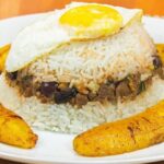 Arroz tapado con carne molida y huevo duro en plato receta peruana