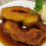 Picarones con miel de chancaca en plato receta peruana