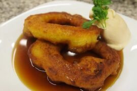 Picarones con miel de chancaca en plato receta peruana