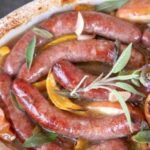 Salchichas a la sidra con manzana, pimiento y cebolla al horno