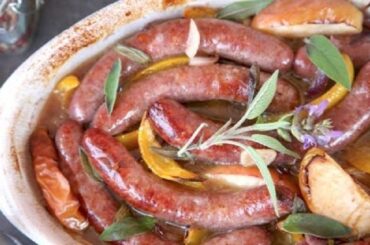 Salchichas a la sidra con manzana, pimiento y cebolla al horno