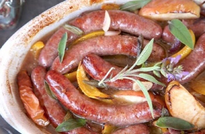 Salchichas a la sidra con manzana, pimiento y cebolla al horno