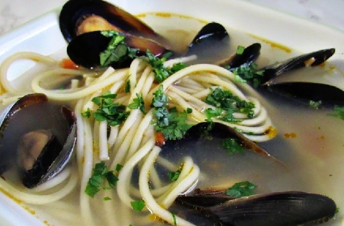Sopa de choros con papa y fideos en plato hondo receta peruana