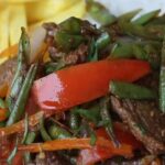 Vainita saltada con cebolla y tomate en sartén receta peruana