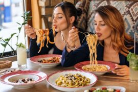 Personas comiendo pasta en un restaurante de Santiago de Chile