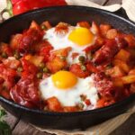 Huevos a la flamenca en cazuela de barro con chorizo y guisantes receta andaluza