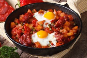 Huevos a la flamenca en cazuela de barro con chorizo y guisantes receta andaluza