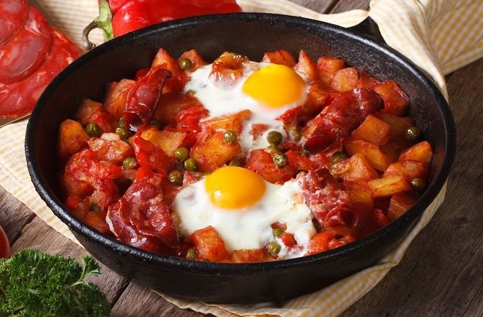 Huevos a la flamenca en cazuela de barro con chorizo y guisantes receta andaluza