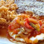 Huevos rancheros mexicanos sobre tortilla de maíz con salsa ranchera receta casera