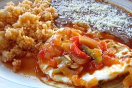 Huevos rancheros mexicanos sobre tortilla de maíz con salsa ranchera receta casera