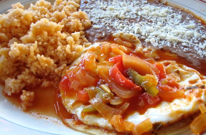 Huevos rancheros mexicanos sobre tortilla de maíz con salsa ranchera receta casera