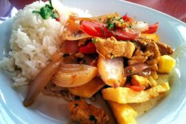 Lomo saltado de pollo con cebolla y tomate en sartén receta peruana