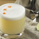 Pisco sour con espuma y gotas de amargo de angostura receta peruana