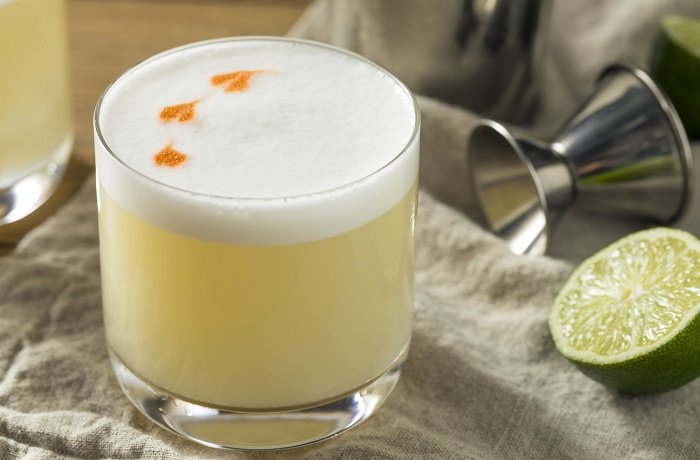Pisco sour con espuma y gotas de amargo de angostura receta peruana
