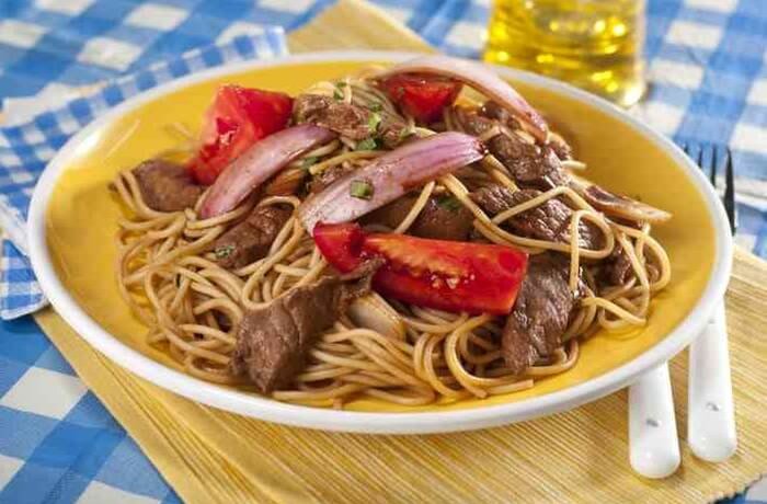 Tallarín saltado de carne con cebolla, tomate y ají amarillo receta peruana