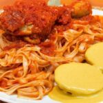 Tallarines rojos con presas de pollo en salsa de tomate receta peruana